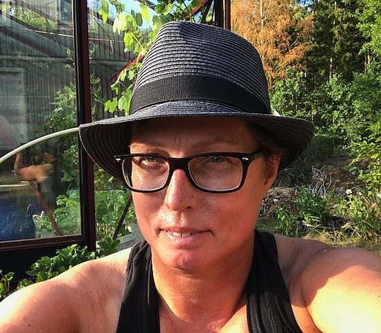 En selfie på kvinna i hatt i en trädgård. Mulching works, Anna Skog Pettersson. 